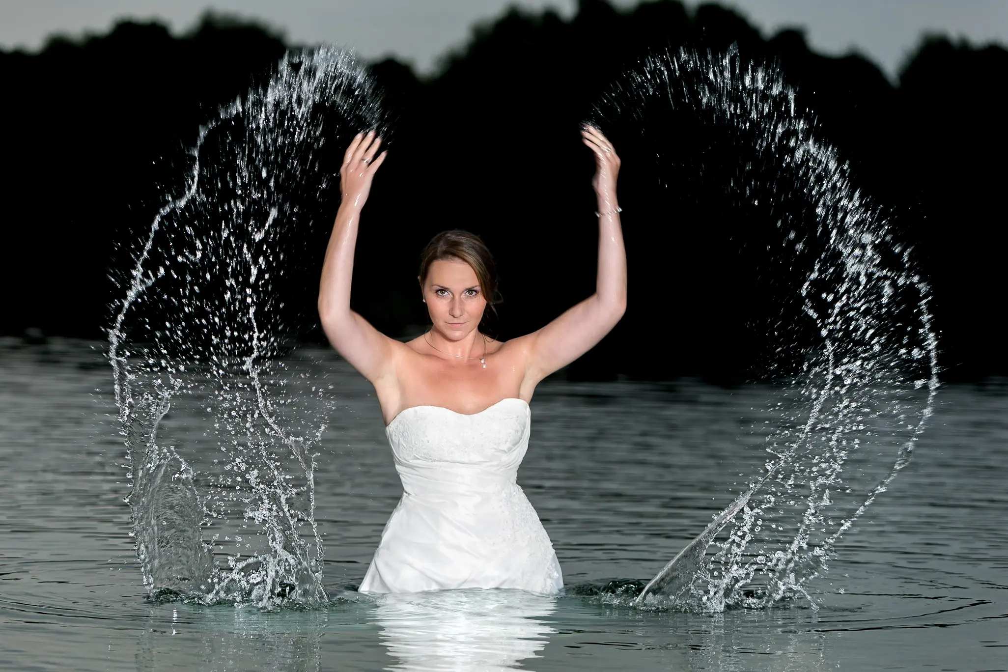 Braut bei Nacht im See mit Brautkleid